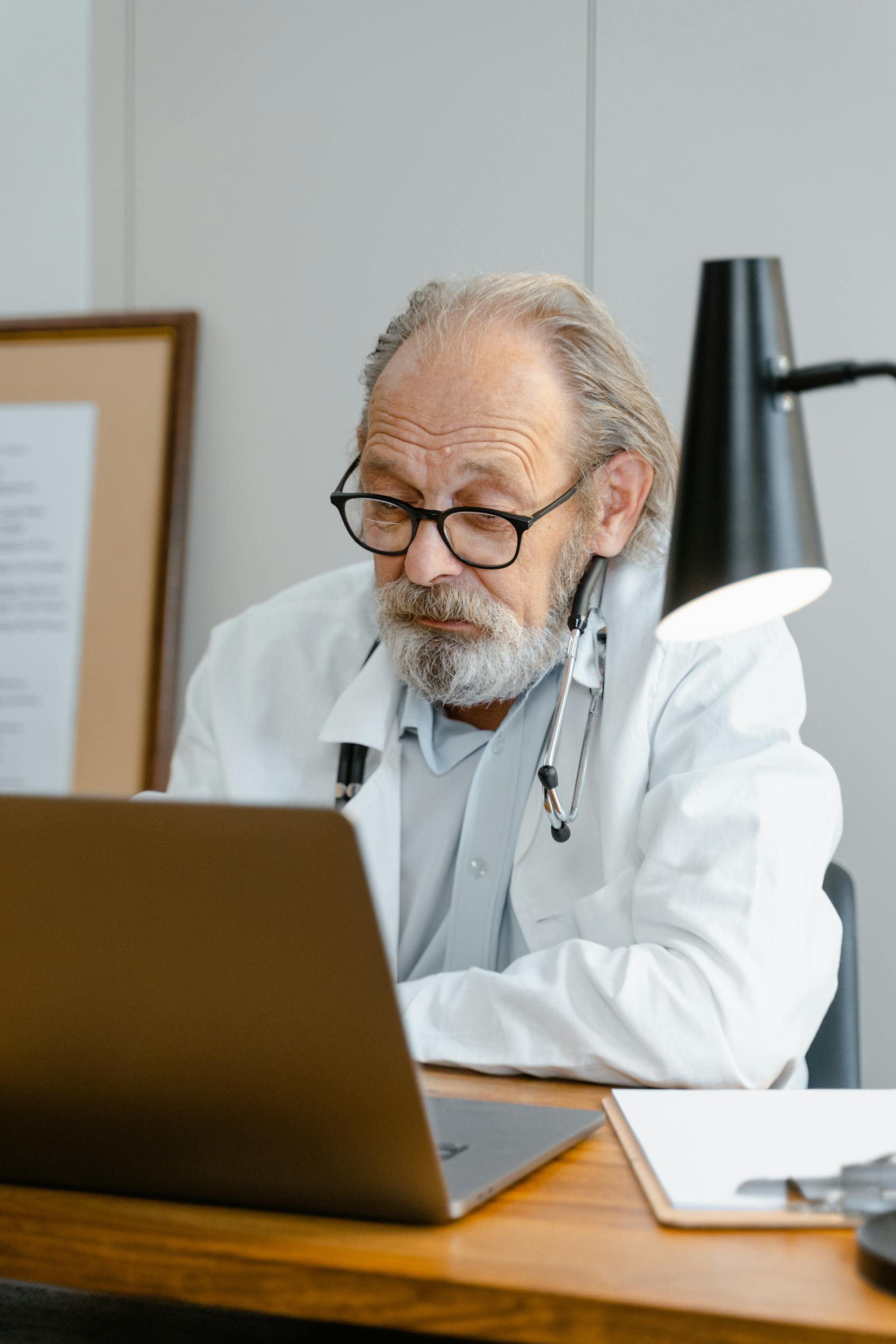 Huisarts die administratie opvolgt aan een laptop