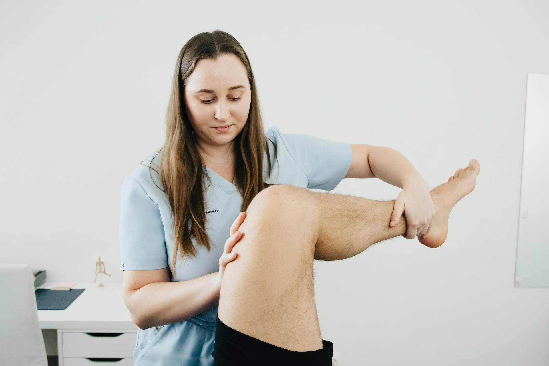 Kinesitherapeut begeleidt een patiënt tijdens een behandeling